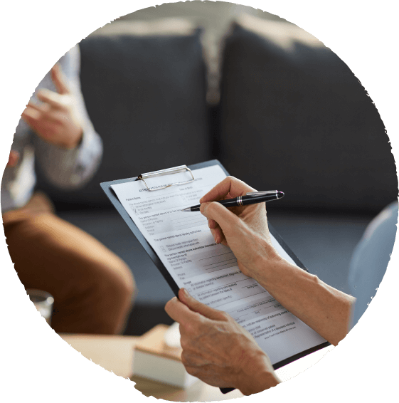 Person filling out a form on a clipboard during a meeting